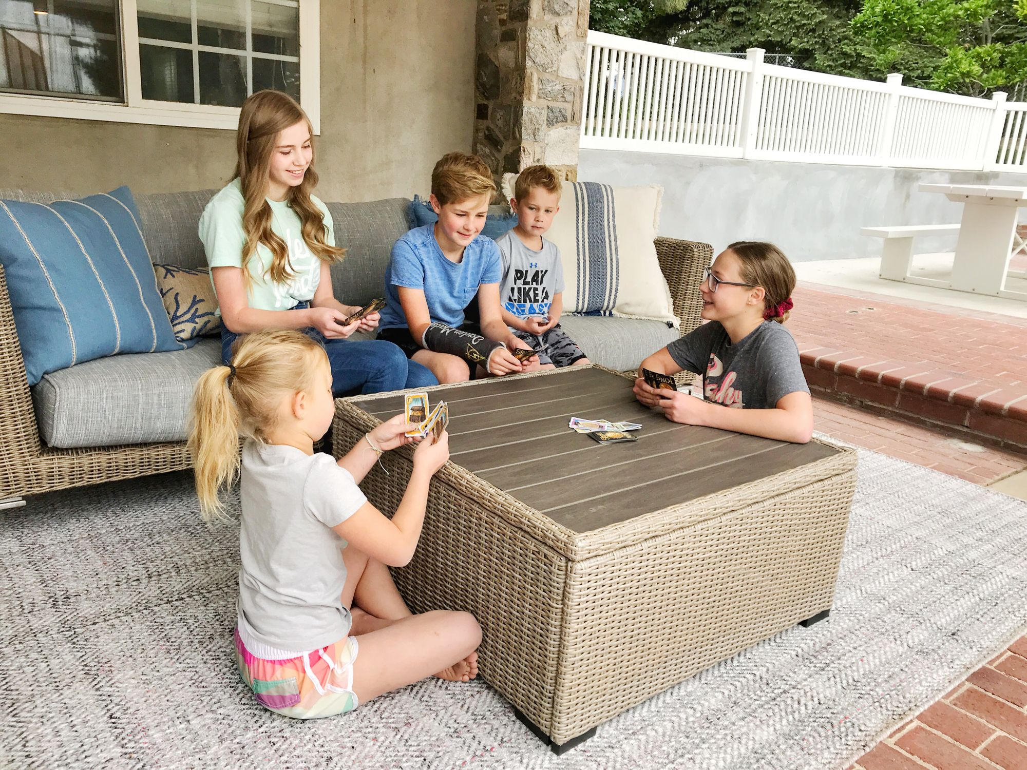 Family kids playing cards on outdoor sofa
